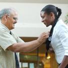 Frank Sousa, a Class of 1974 School of Medicine graduate and now a clinical professor, presents a new stethoscope to Ekama Onofiok, class of 2008. 