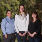 Portrait of five academic advisors, posed in a line, in the arboretum