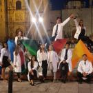 Students in white coats, posing at night in Oaxaca.