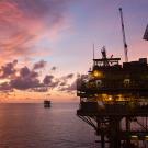 An offshore oil rig at sunset