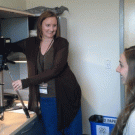 Photo: Woman takes an employee&rsquo;s photo for AggieCard.