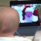 Santa speaks to two children via a Zoom call.