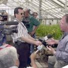 photo of man being interviewed by television reporters with cameras