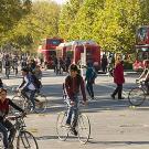 Scene at the UC Davis campus street with many bikes and double-decker buses in the background
