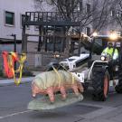 Waterbear statue being moved by forklift.