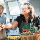 A woman vendor greets customers at the farmer's market