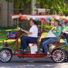 A decorated bike cart zooms past on Picnic Day