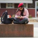 A student in a pink jacket and a red beret uses her smartphone outside of the CRAFT Center on February 14, 2023.