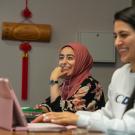 Two students smile at their laptops at UC Davis. 