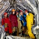 Five UC Davis researchers inside marble rock formations of cave