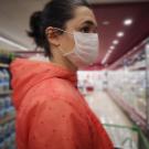 Woman wearing mask looks at groceries in store