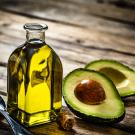 A UC Davis study finds most private label avocado oils are either rancid or adulterated. No enforceable standards for avocado oil exist yet. Pictured here is a bottle of avocado oil and spoon next to a cut avocado. (Getty Images)