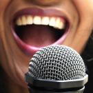 Photo of woman's mouth in front of microphone