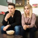 Man and woman watching television of movie in home looking intently