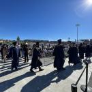 UC Davis graduates walk in cap and gown at sunny commencement