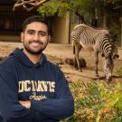 Jeevan Mann poses with a zebra in the background at the Sacramento Zoo