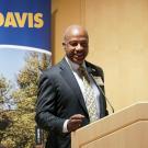 Chancellor Gary S. May at podium, with UC Davis banner behind him