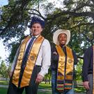 Three male undergraduates wearing graduation stoles outside