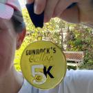 Woman holds Gunrock's Galop 5K medal