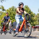 Two students ride Spin Bikes through bike circle 