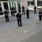 Campus fire personnel, in uniform, posing in semicircle.