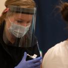 A UC Davis student EMT administering a COVID-19 vaccine at a campus clinic. 