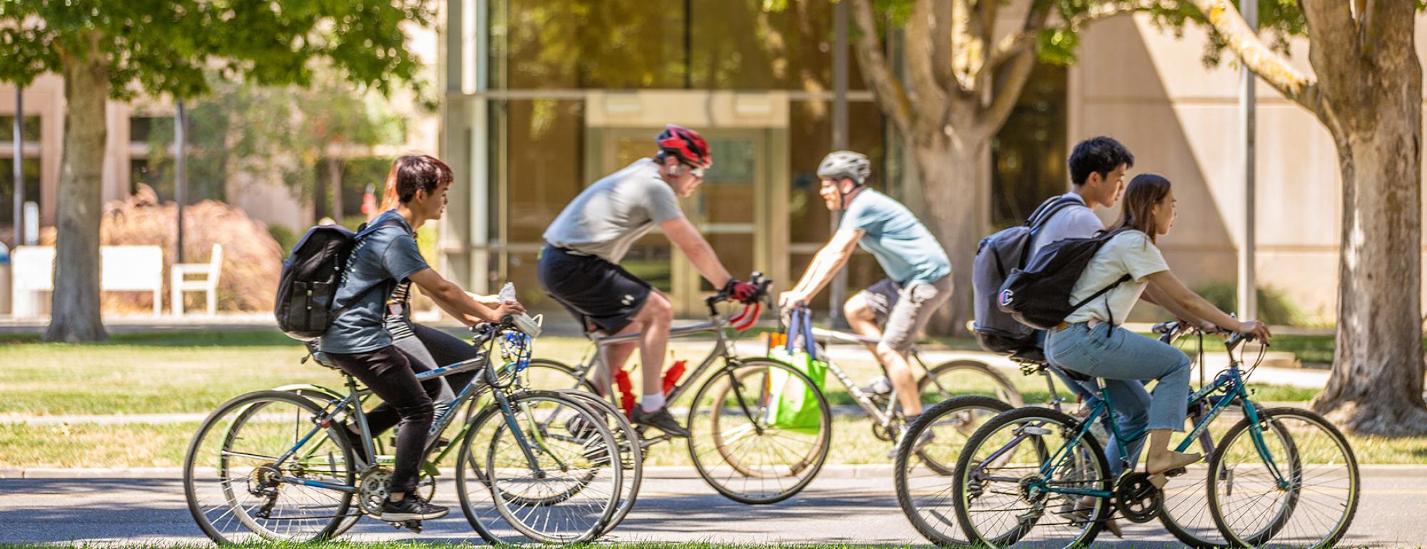 students riding bicycles in front of the quad
