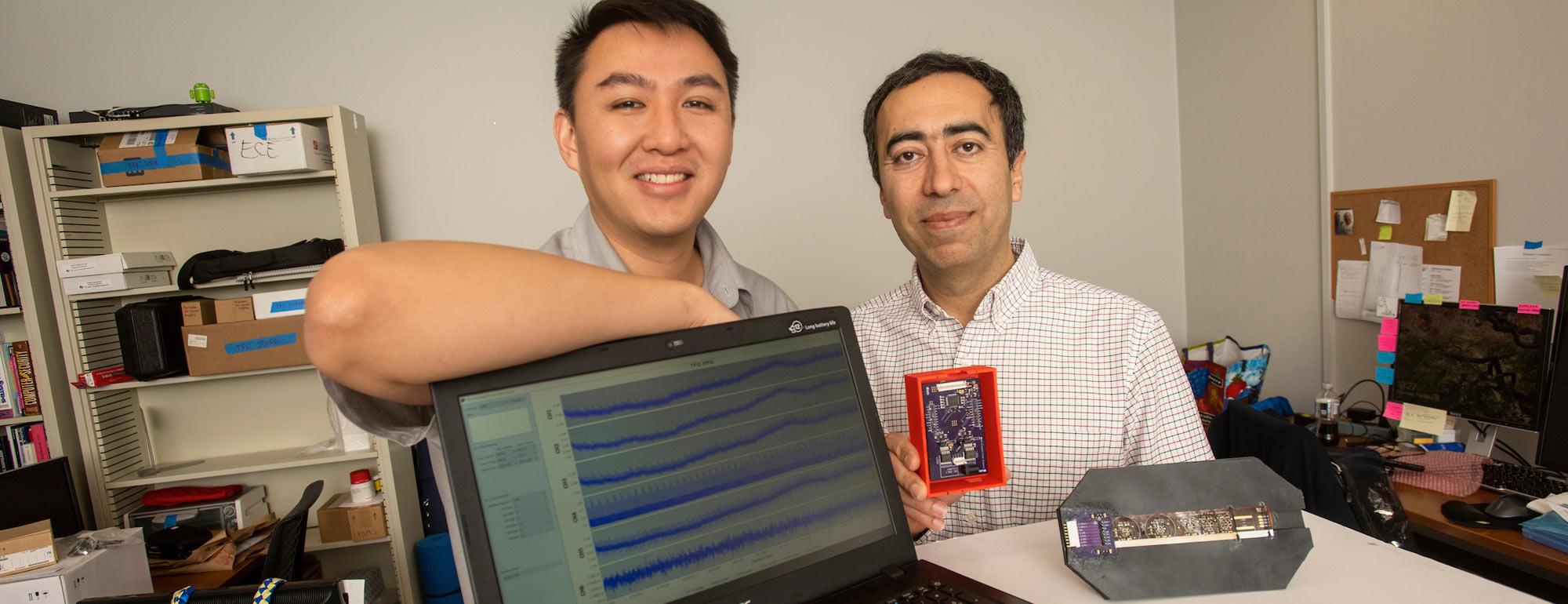 A student and professor pose next to their computer engineering project