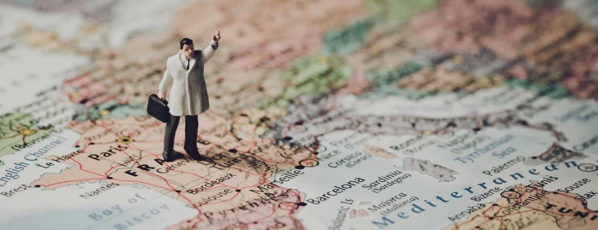 mini action figure stands on France on world map