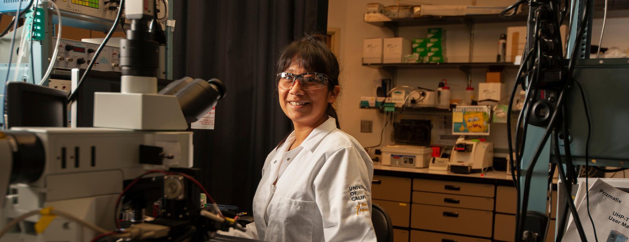 A female researcher smiles in her lab