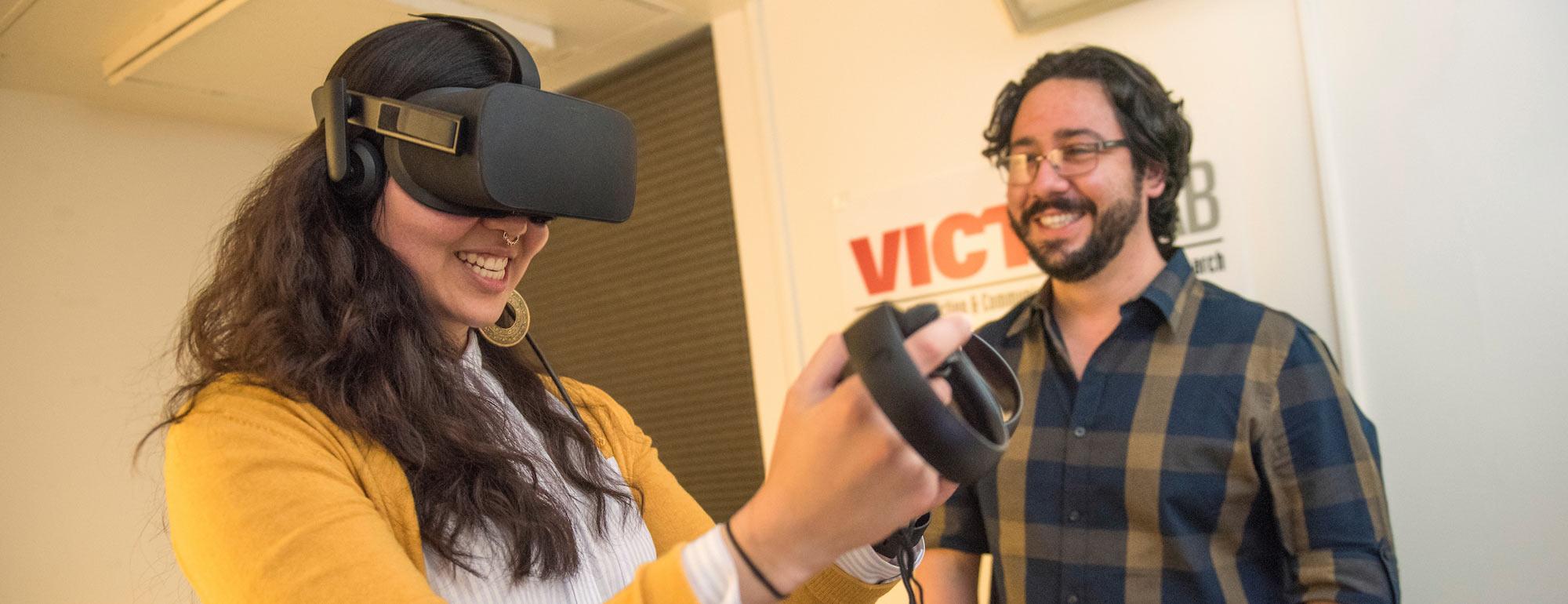 A student smiles while using a virtual reality set up.