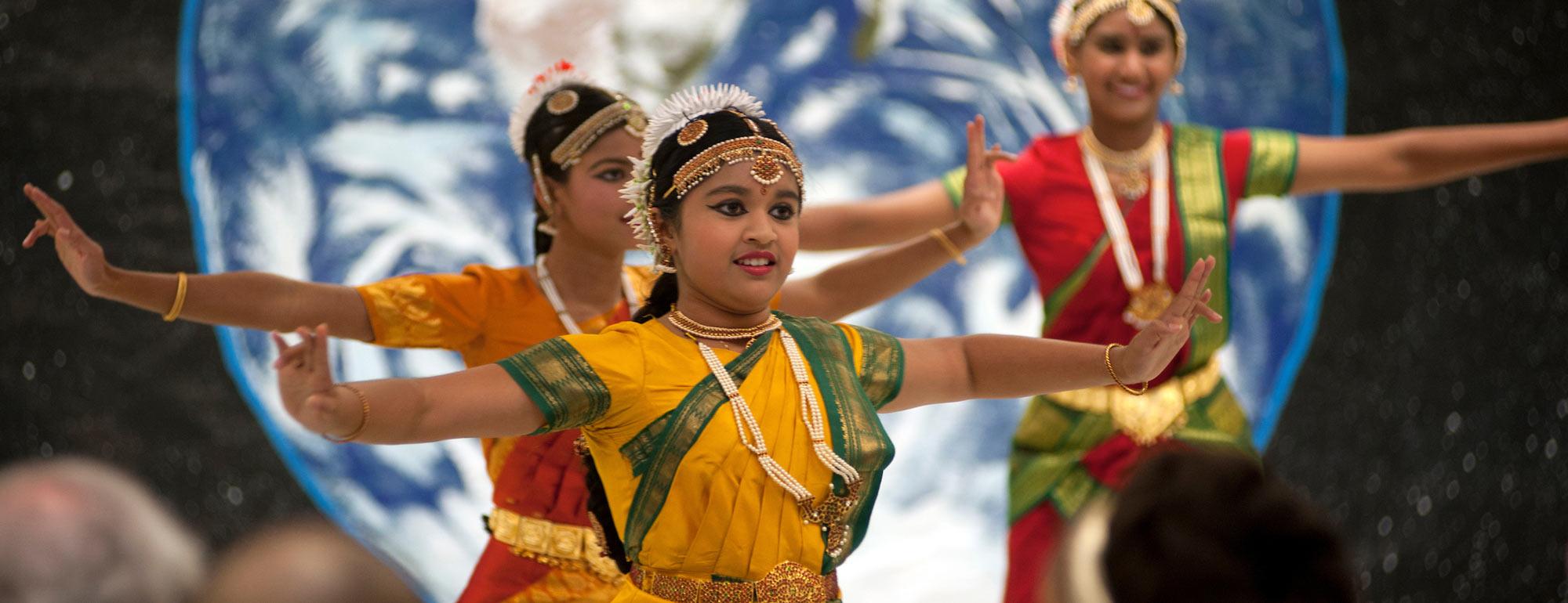 A group of young women preform a South Asian style dance