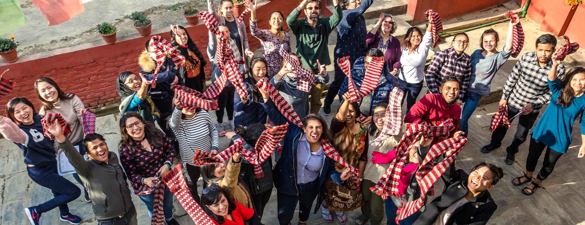 Students smile and hold up colorful scarves on study abroad at UC Davis. 
