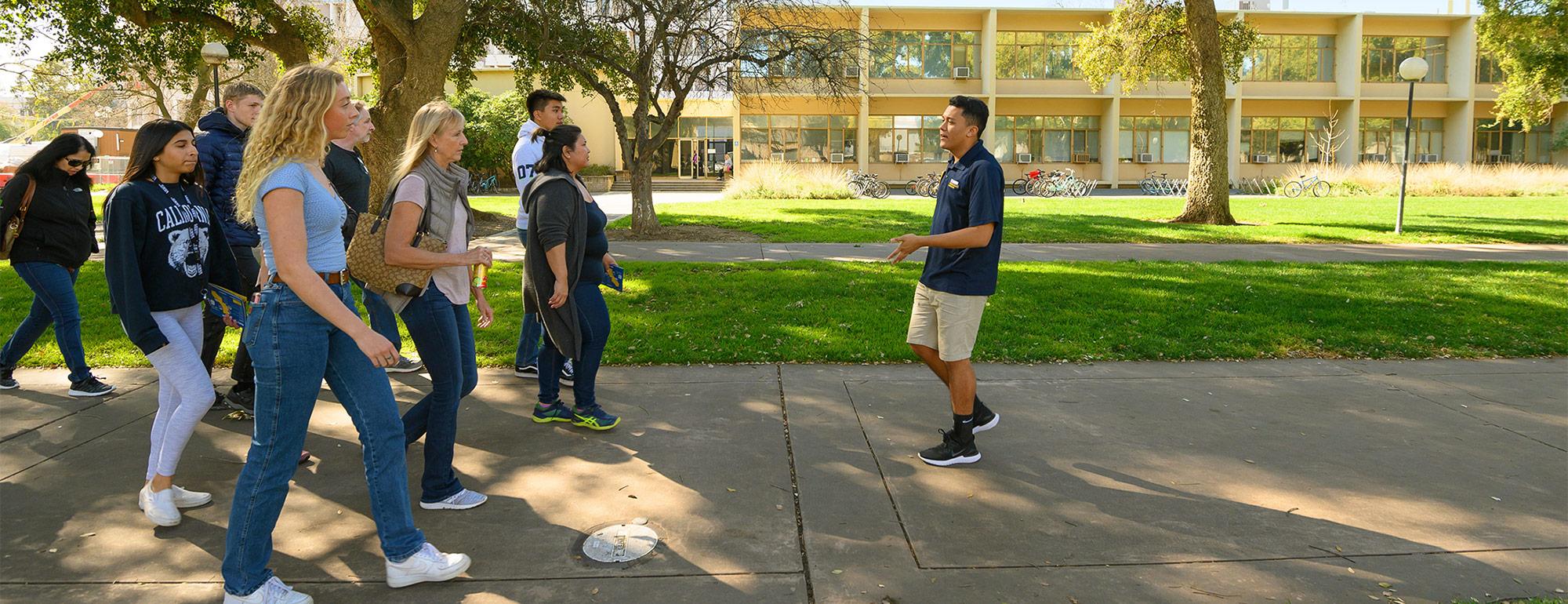 a student tour guide leading a group of people on a campus tour