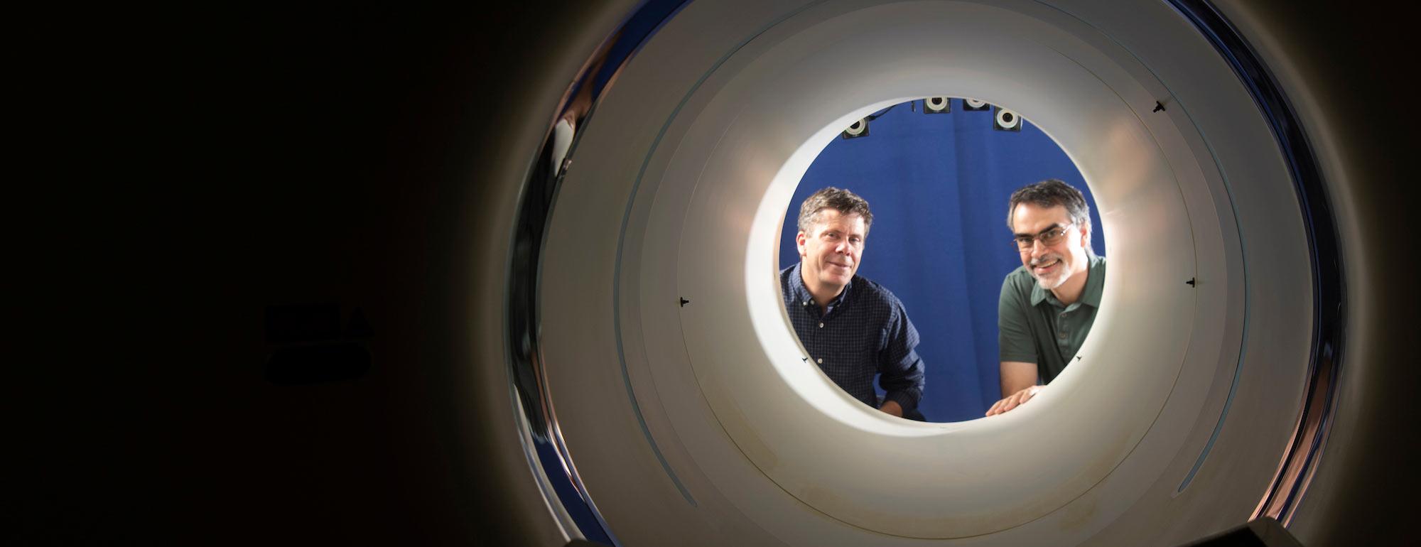 Two men pose at the opening of a new full body PET scanner that allows for easier medical diagnostics