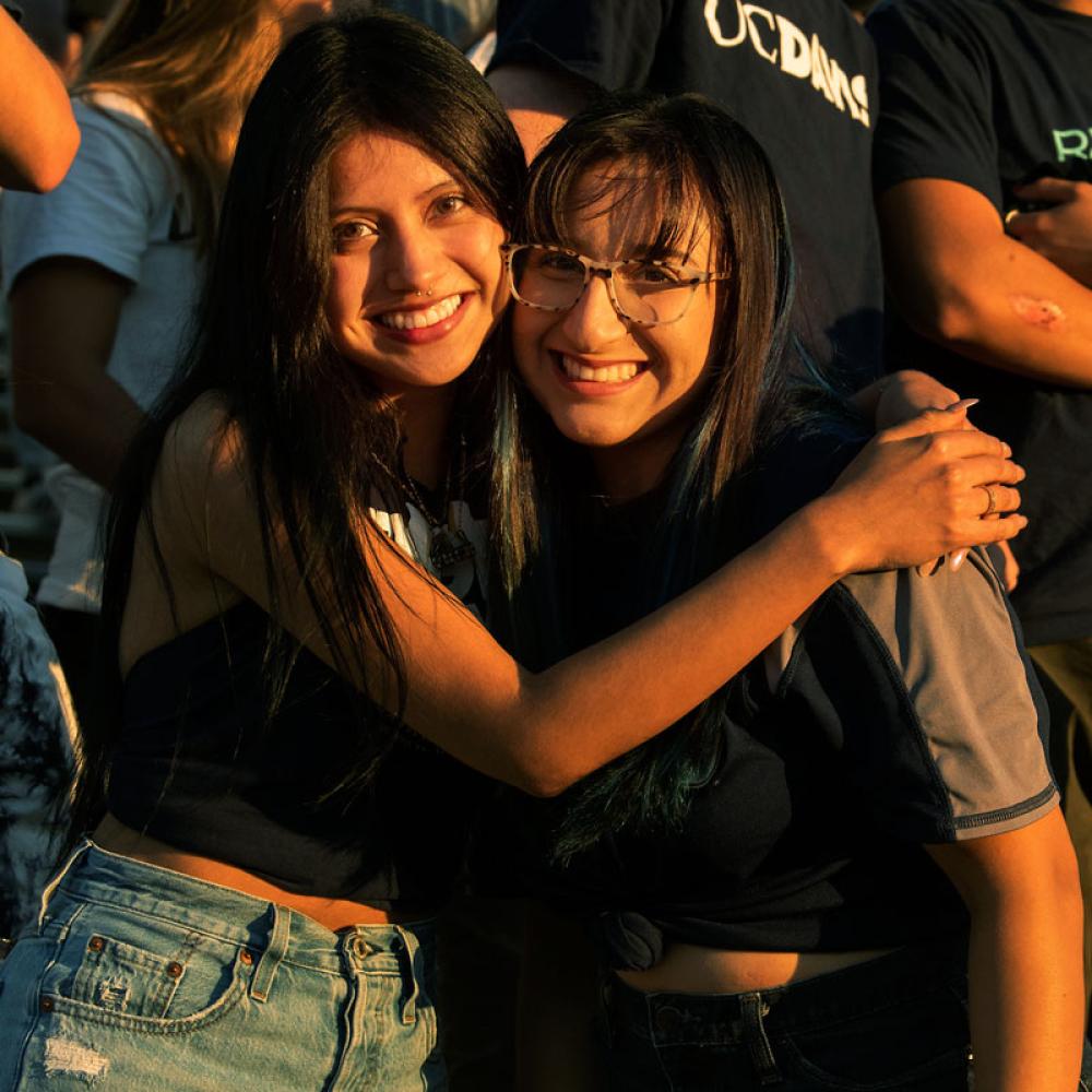 Two students hug at a UC Davis football game