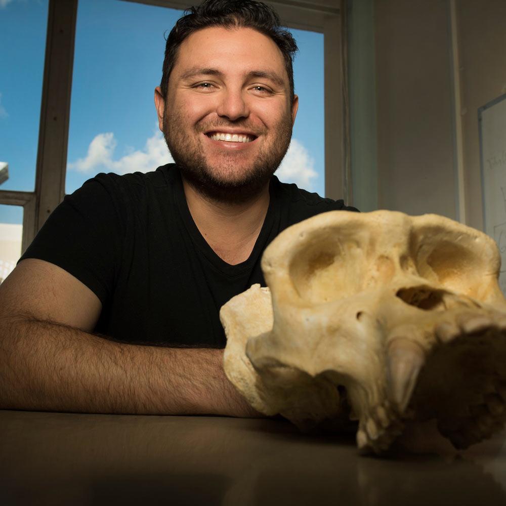 A student poses with an ape skull