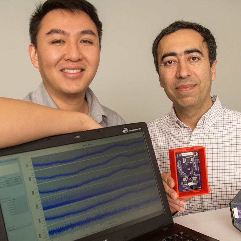 A student and professor pose next to their computer engineering project