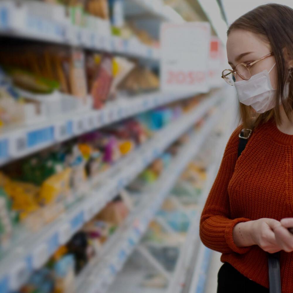 girl shops while wearing breathing mask