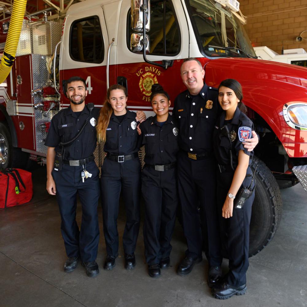 a group of fire fighters standing in front of a fire truck