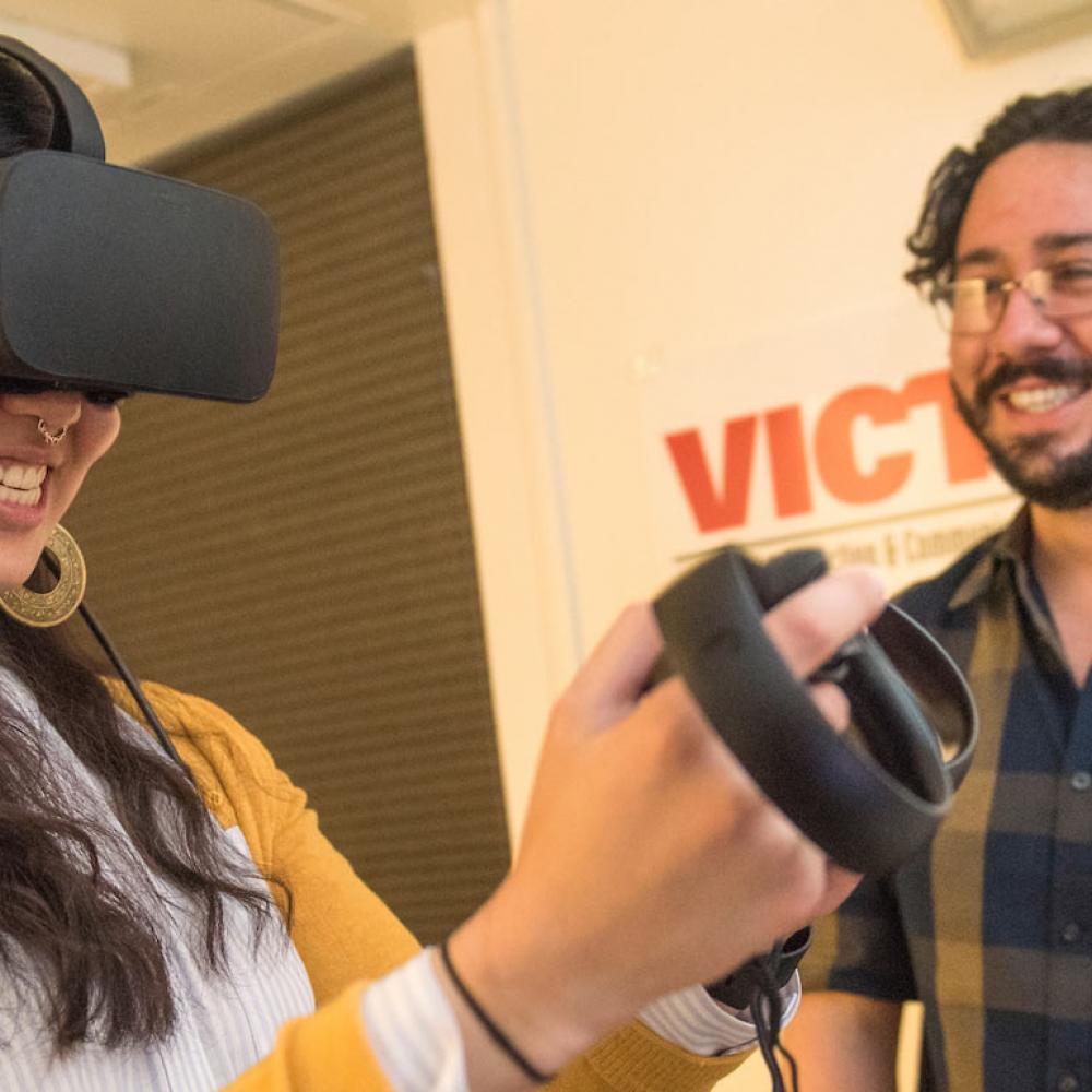 A student smiles while using a virtual reality set up.