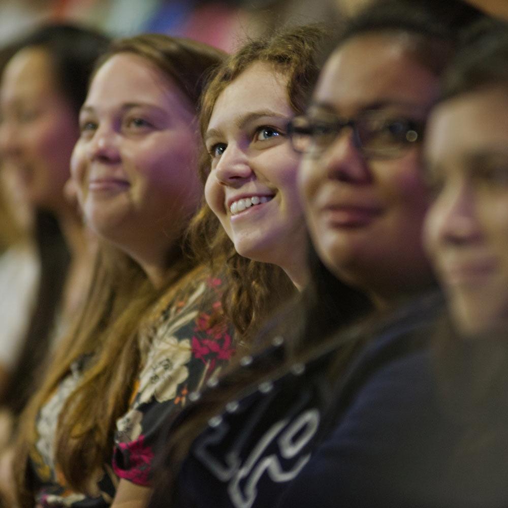 A female UC Davis student smiles in a crowd