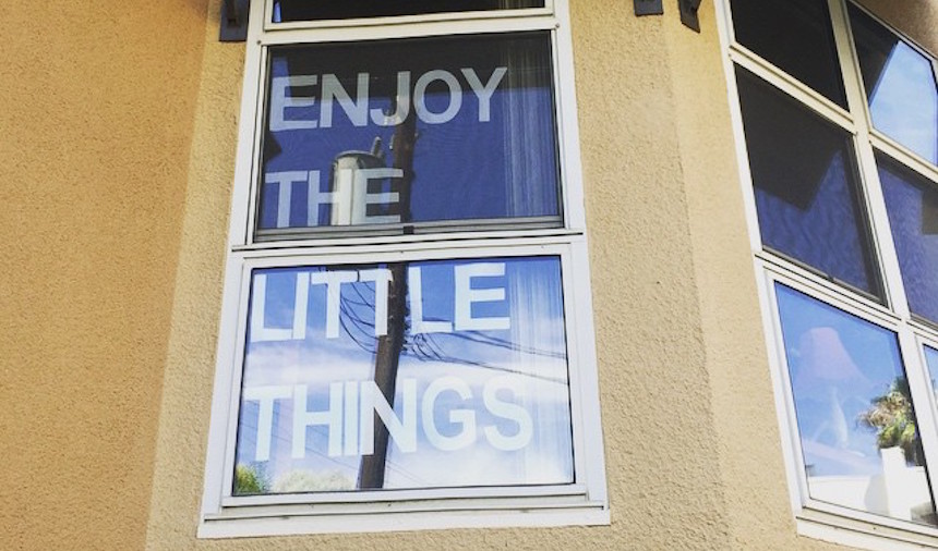 'Enjoy the little things' displayed on a window