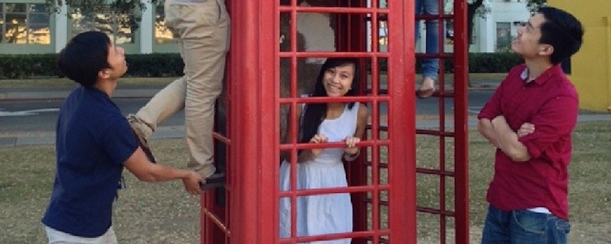 Students posing around a red telephone booth