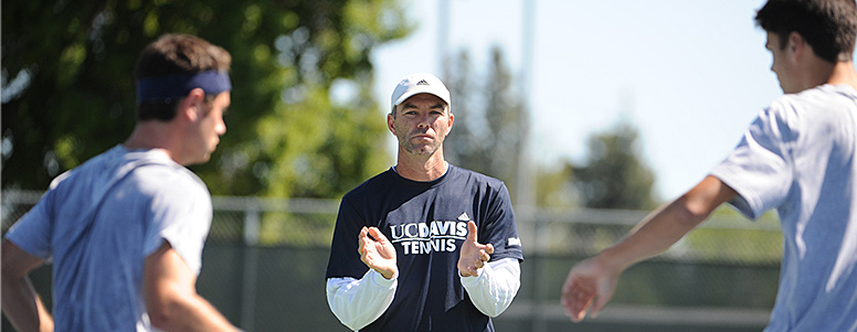 Tennis coach Eric Steidmayer talking to two players in the foreground