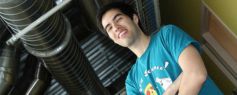 Male student with a food science T-shirt standing in an industrial-looking building