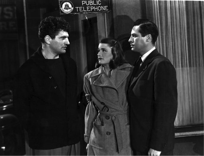 Old noir-style movie set in black and white with two men and a woman talking