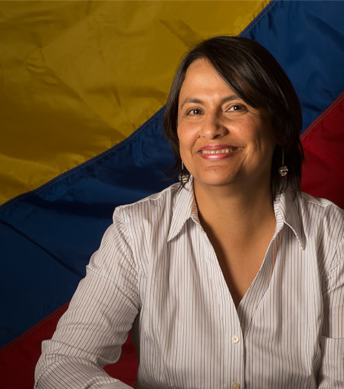 Tania Guzman in front of a Colombian flag