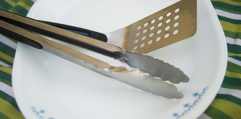  cooking tongs and spatula on a platter