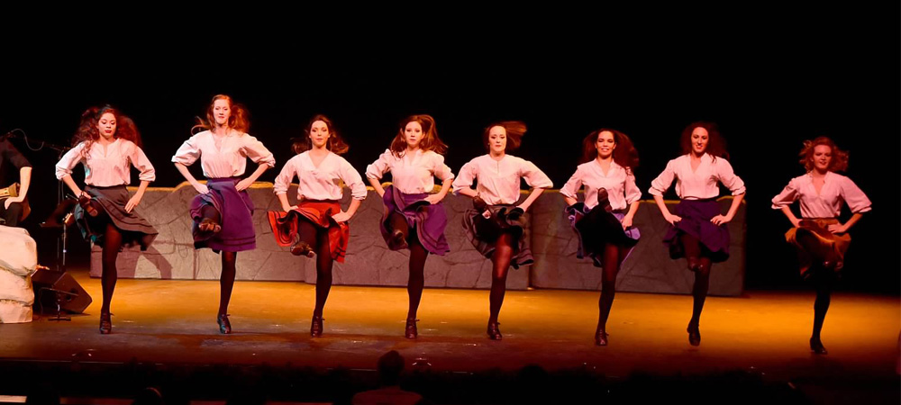 Eight dancers performing an Irish line dance.